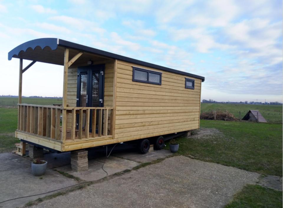 Houten pipowagen op het weiland